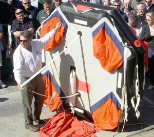 Moderator Bruce Brown demonstrates a life raft at a safety seminar.(Rousmaniere)